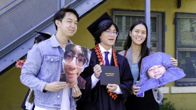 grad posing with parents