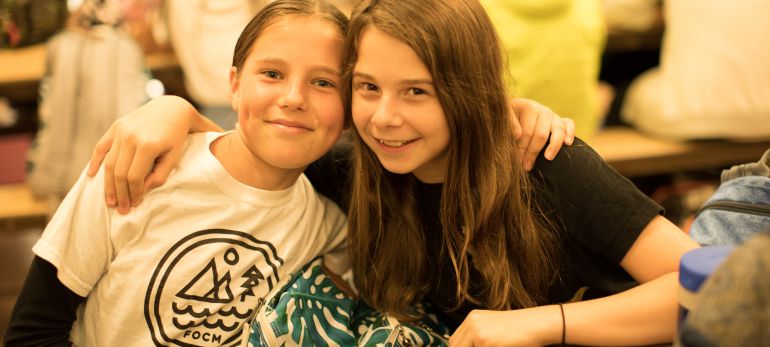 Female middle school students pose for the camera at lunch