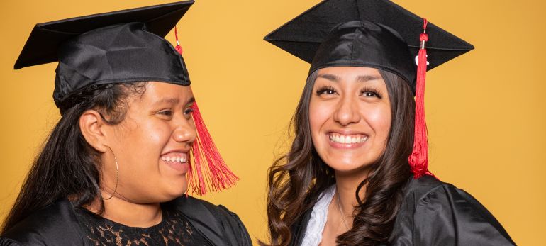 two female graduates smiling